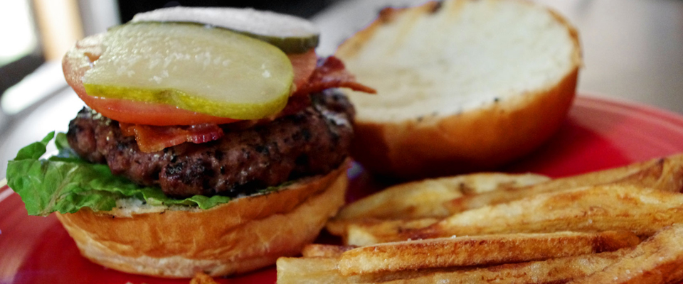 A Winn's burger with bacon, lettuce, tomato and pickle, served with hand-cut fries.