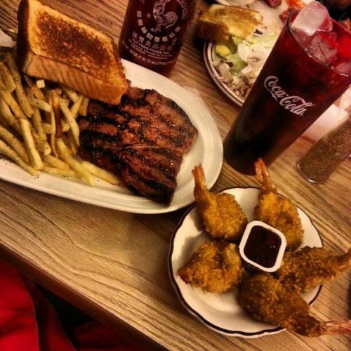Steak with Texas toast and fries, with breaded shrimp on the side.